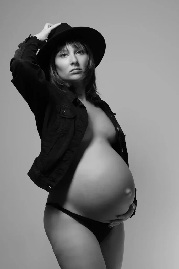 a pregnant woman wearing a hat and a jacket